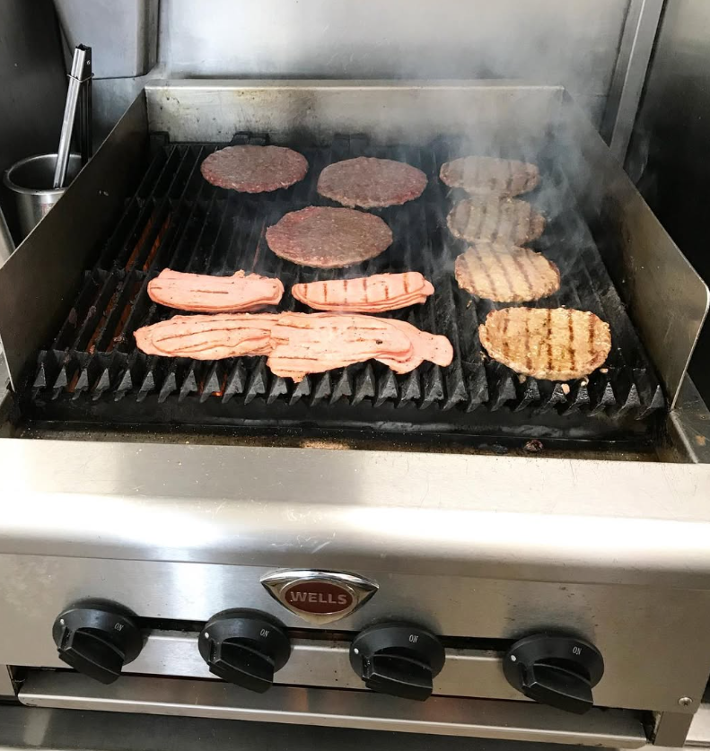 Burgers and patties cooking on the grill