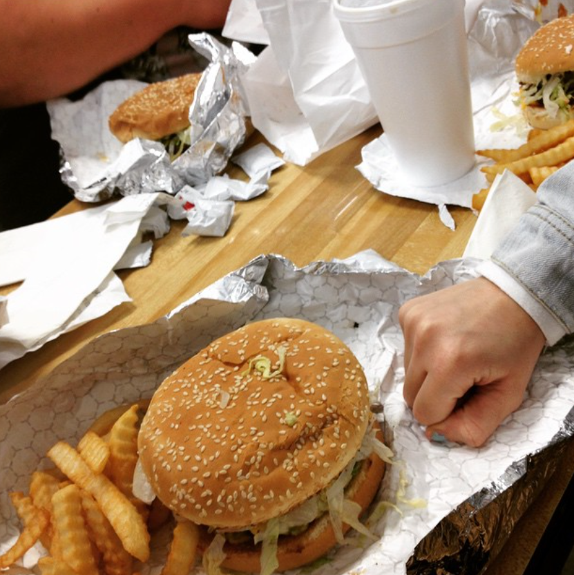 Burger and fries at a table with drinks