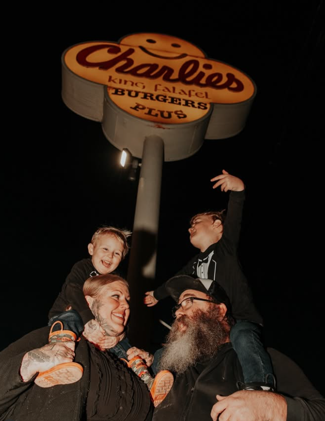 Charlies family under the sign at night