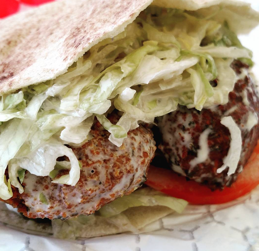 Close-up of falafel inside pita with lettuce and tomatoes